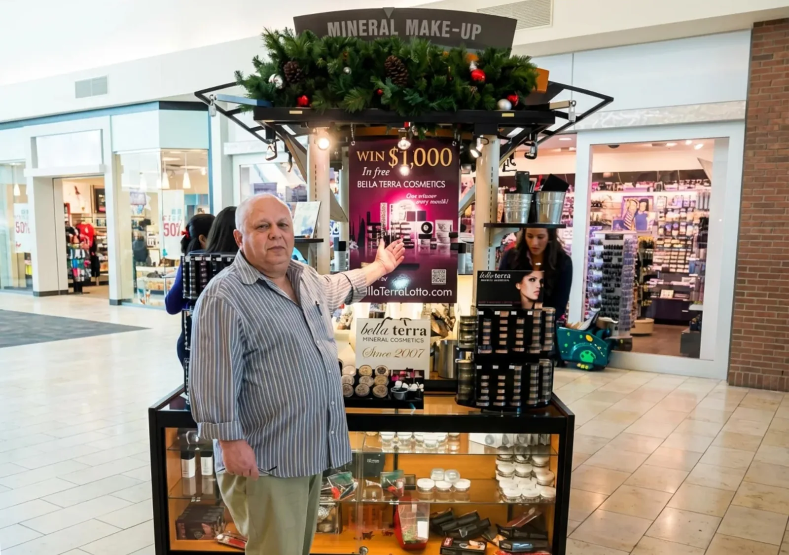 A BELLATERRA mineral makeup kiosk in a shopping mall during the holidays