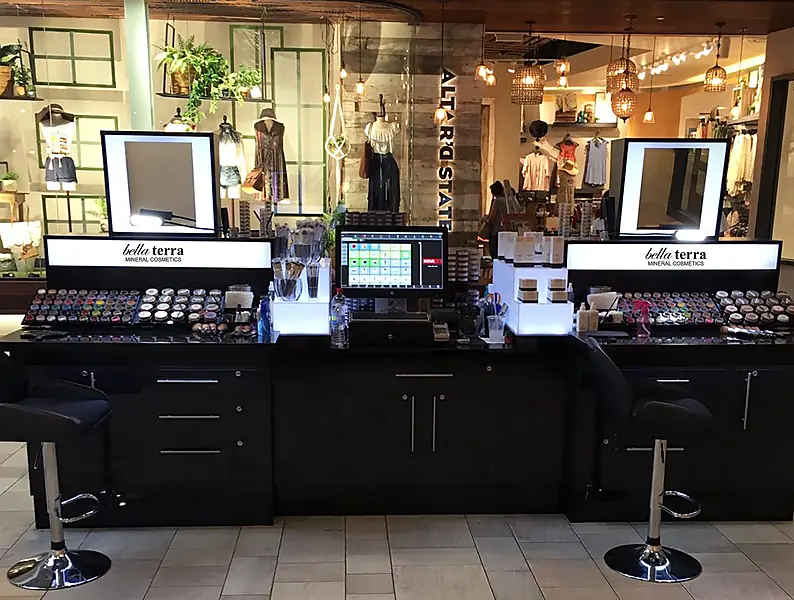 BELLATERRA mineral makeup kiosk with lit mirrors, stools and a checkout screen, 2016