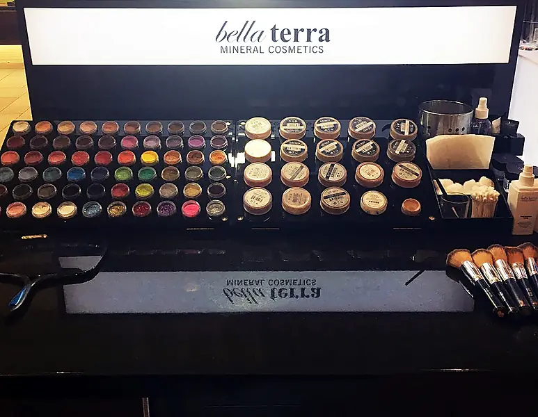 Tray of BELLATERRA mineral eyeshadows and foundations under the kiosk light box, 2016